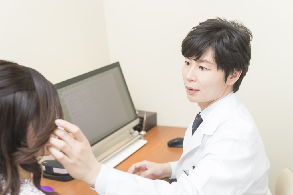 医師が肌の状態と毛の状態を確認しながら照射の可否を説明している様子